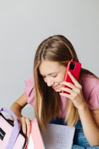 Kaboompics - Student Looking at Phone with Backpack