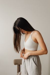 Kaboompics - Woman in White Tank Top and Gray Lounge Pants in a Neutral Home Lifestyle Portrait