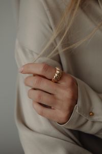 Kaboompics - Woman's Hand Holding Tan Silk Shirt with Gold Ring
