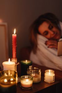 Kaboompics - Woman Reading in Bed by Candlelight with a Blanket
