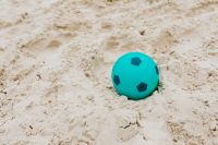 Kaboompics - Turquoise Toy Ball on Pale Beach Sand for Minimal Summer Backgrounds