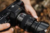 Kaboompics - Black Cinema Camera with Lens Hood Held Outdoors