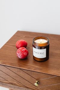 Kaboompics - Soy Candle and Red Plums on Walnut Furniture for Neutral Interior Moodboards