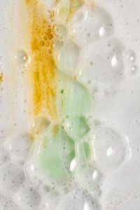 Kaboompics - Golden Yellow and Mint Cream Swatches in White Bubbly Foam, Skincare Macro