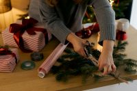 Kaboompics - Hands Decorating Evergreen Garland for Gift Wrapping