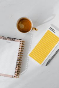 Kaboompics - Top view of a marble desk with coffee, notebooks and pen