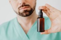 Kaboompics - Doctor Holding Amber Dropper Bottle Close-Up