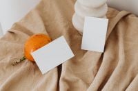 Kaboompics - Overhead Orange Fruit with Two Blank Cards and White Ceramic Vase