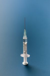 Kaboompics - Single Syringe Standing on Blue Background