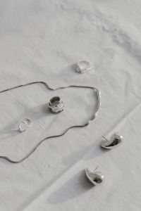 Kaboompics - Silver Jewelry and Chain Flat Lay on White Fabric