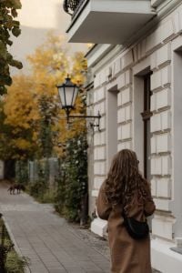 Kaboompics - Woman in Camel Coat Walking Along a Historic City Street