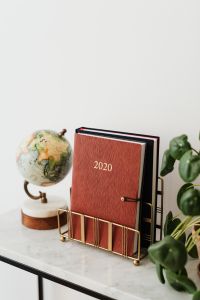 Kaboompics - 2020 Planner Workspace with Globe and Pilea Copy Space