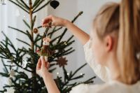 Kaboompics - Child Hanging Handmade Ornament on Christmas Tree
