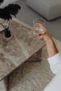 Kaboompics - Hand Holding a Glass Over a Marble Table