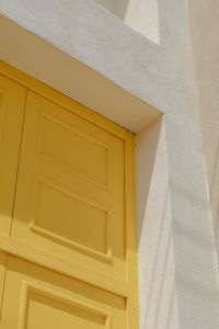 Kaboompics - Yellow Paneled Door with Sunlit White Architectural Wall