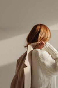 Kaboompics - Faceless Woman in White Sweater Adjusting Hair with Beige Coat
