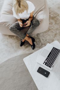 Kaboompics - Overhead Home Office Break: Woman Checking Phone on Couch