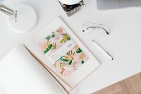 Kaboompics - Open Illustrated Planner with Glasses and White Pen on Desk