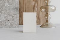 Kaboompics - Wide Blank Business Card Mockup beside Marble Slab and Glass Candlestick on Wood