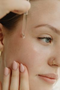 Kaboompics - Applying Facial Serum with a Dropper and Fingertips to the Cheek