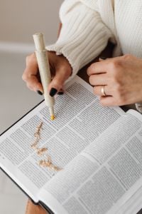 Kaboompics - Hands Highlighting Bible Verses with a Cross Necklace on the Page