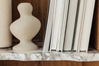 Kaboompics - Wide Neutral Shelf Styling with Books and a Sculptural Ceramic Vase