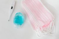 Kaboompics - Pink Masks, Thermometer and Blue Sanitizer Flat Lay