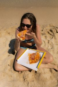 Kaboompics - Smiling Woman with Pizza at the Water’s Edge