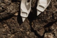 Kaboompics - White Buckle Pumps in a Close-Up Rocky Beach Composition