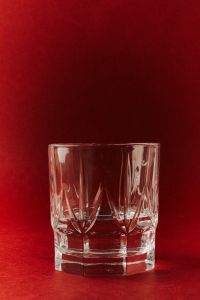 Kaboompics - Faceted Whiskey Glass on Red Background
