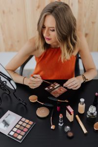 Kaboompics - Woman Holding an Eyeshadow Palette and Makeup Brush at the Vanity