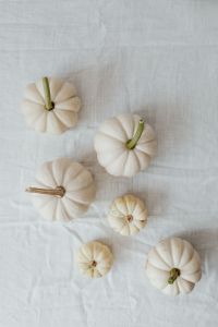 Kaboompics - White Mini Pumpkins Spaced Across a Linen Tablecloth