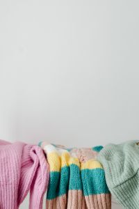 Kaboompics - Pastel Sweaters Folded on a White Rack