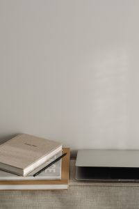 Kaboompics - Neutral Home Office Background with Closed Laptop, Books and Wall Copy Space
