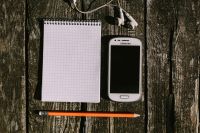 Kaboompics - Nostalgic Samsung Smartphone With Earphones and Grid Notebook