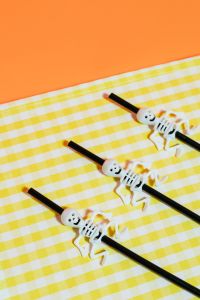 Kaboompics - Halloween Skeleton Straws on Yellow Checkered Fabric