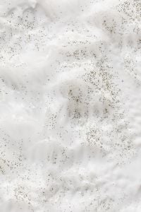 Kaboompics - Vertical White Skincare Cream and Dark Speckles, Abstract Beauty Macro Texture
