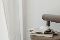 Kaboompics - Neutral Armchair beside Sheer Curtain with Open Book and Copy Space
