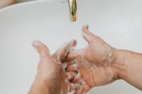 Kaboompics - Open Palm Lathering under a Faucet over a Minimal White Sink, Handwashing Instruction