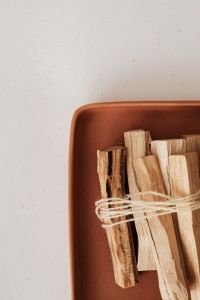 Kaboompics - Palo Santo Sticks in a Rust Terracotta Bowl, Neutral Wellness Still Life
