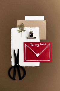 Kaboompics - Red Love Letter Envelope with Scissors and Paper Flatlay