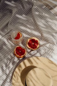 Kaboompics - Grapefruit Half and Pink Drink in a Glass on a Striped Towel