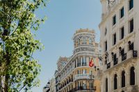 Kaboompics - Madrid Historic Facade with Spanish Flag and Green Branches, Street-Level View