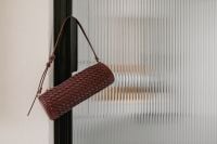 Kaboompics - Burgundy Woven Shoulder Bag on Glass Door