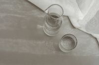 Kaboompics - Single Water Glass on Black Leather Chair With Hard Shadows