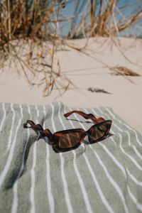 Kaboompics - Tortoiseshell Sunglasses on a Striped Beach Towel