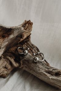 Kaboompics - Silver Ball Drop Earrings on Driftwood and Linen