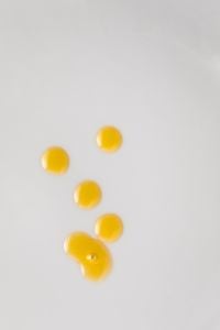 Kaboompics - Golden Skincare Oil Droplets on Light Gray Background with Copy Space
