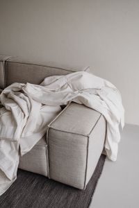 Kaboompics - White Linen Draped Over Neutral Sofa Armrest – Fujifilm X100VI