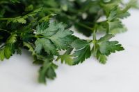 Kaboompics - Macro Flat-Leaf Parsley Sprig on a Pale Surface, Green Herb Texture for Recipe Backgrounds